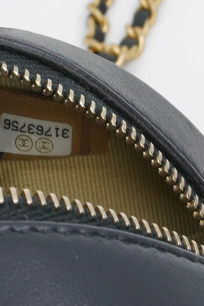 Chanel Pearl Crush runde Clutch aus schwarzem Lammleder, gebrauchter Artikel, Zoom auf den Reißverschluss und die Innenseite der Tasche