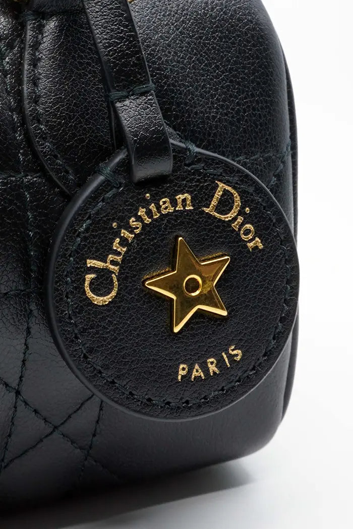 Nano bolso Dior Groove 17 en piel de becerro negra, artículo seminuevo, zoom en la decoración del bolso con el logotipo de la estrella