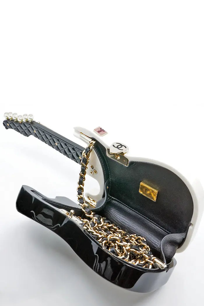 Clutch guitarraChanel , colección 24A Métiers d'Art, artículo de segunda mano, vista abierta con su bandolera de piel entrelazada y cadena