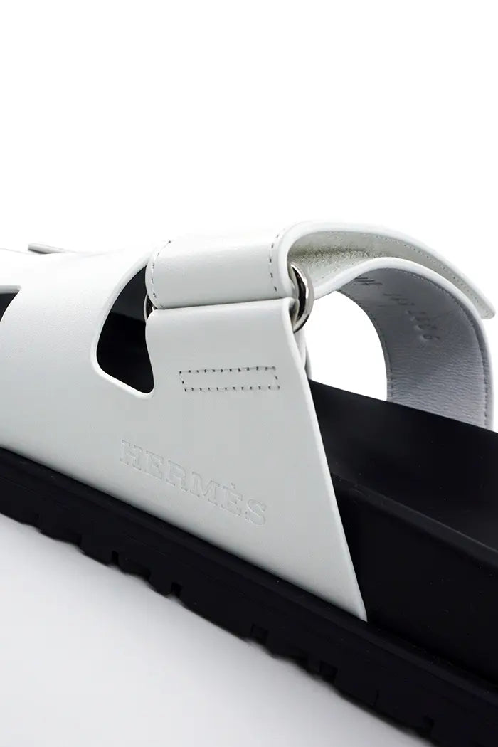 Hermès logo on the Hermès Chypre sandal in white leather. Pre-owned.