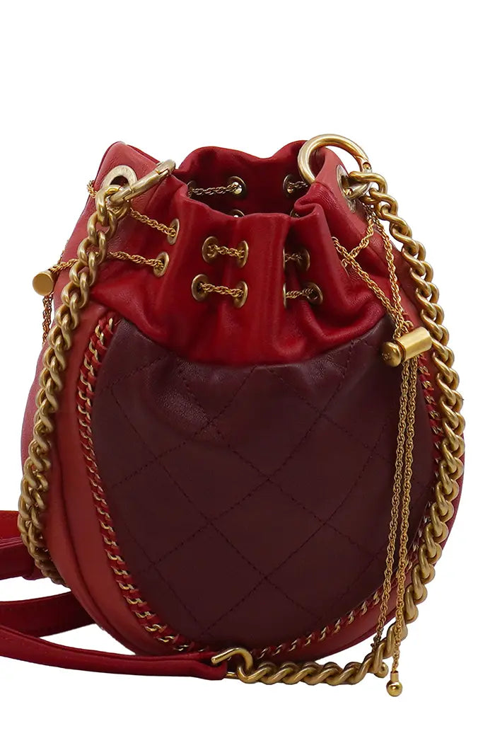 Gros plan sur la fermeture à cordon du sac Chanel en cuir rouge, en très bon état.