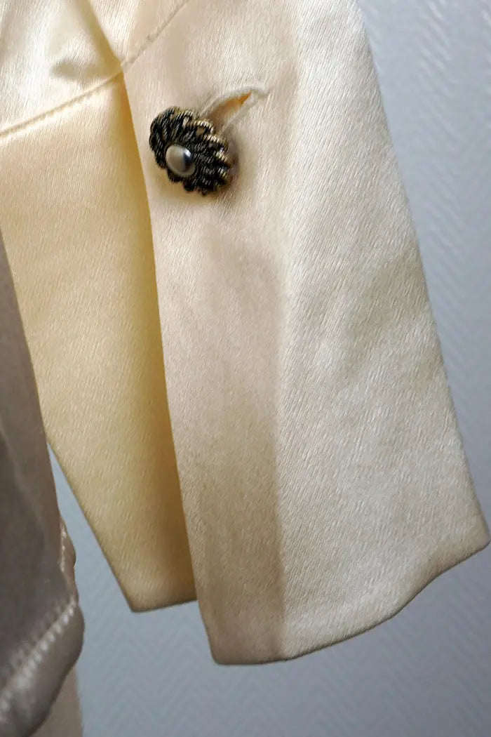 Zoom in on the buttoned cuff of the Chanel preloved blouse