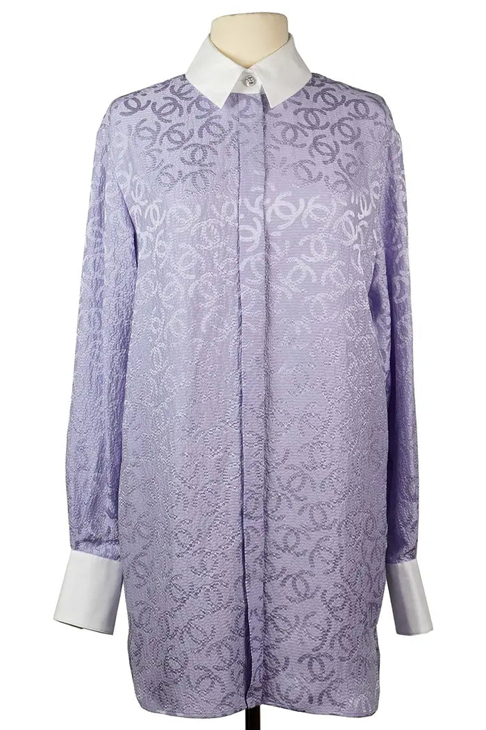 Chanel tunic in mauve silk with white collar and shiny CC motif buttons, seen from the front.