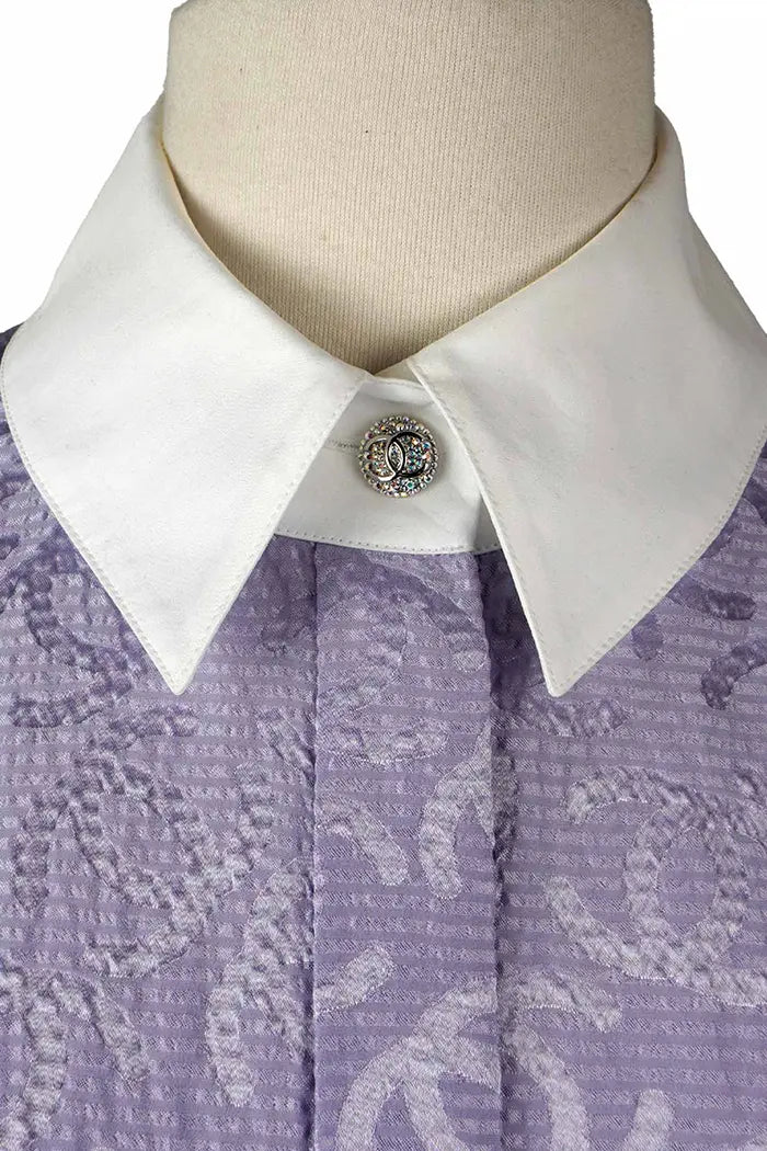 Nahaufnahme der glänzenden Knöpfe mit verschlungenem CC-Muster auf der preloved Chanel Tunika