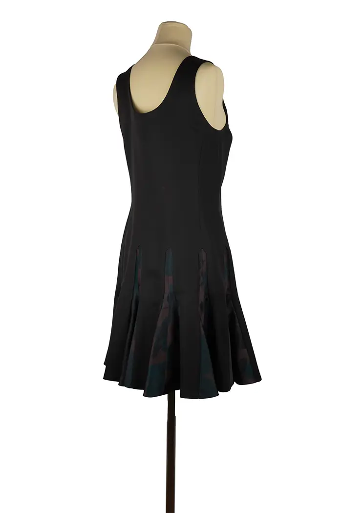 Détail du haut noir en laine à col rond sur mannequin, coupe épurée et satinée, parfaite pour un look sobre et raffiné en soirée.