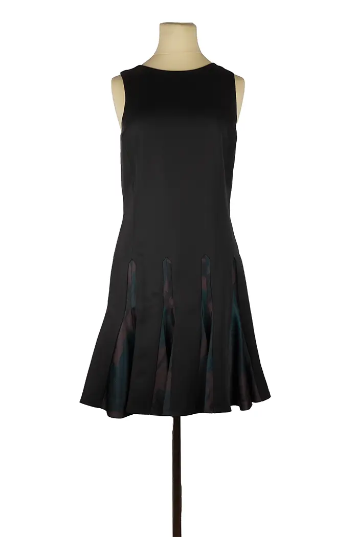 Robe courte Christian Dior en laine et soie satinée sur mannequin, haut noir structuré et jupe imprimée raffinée, idéale pour un look de soirée élégante.