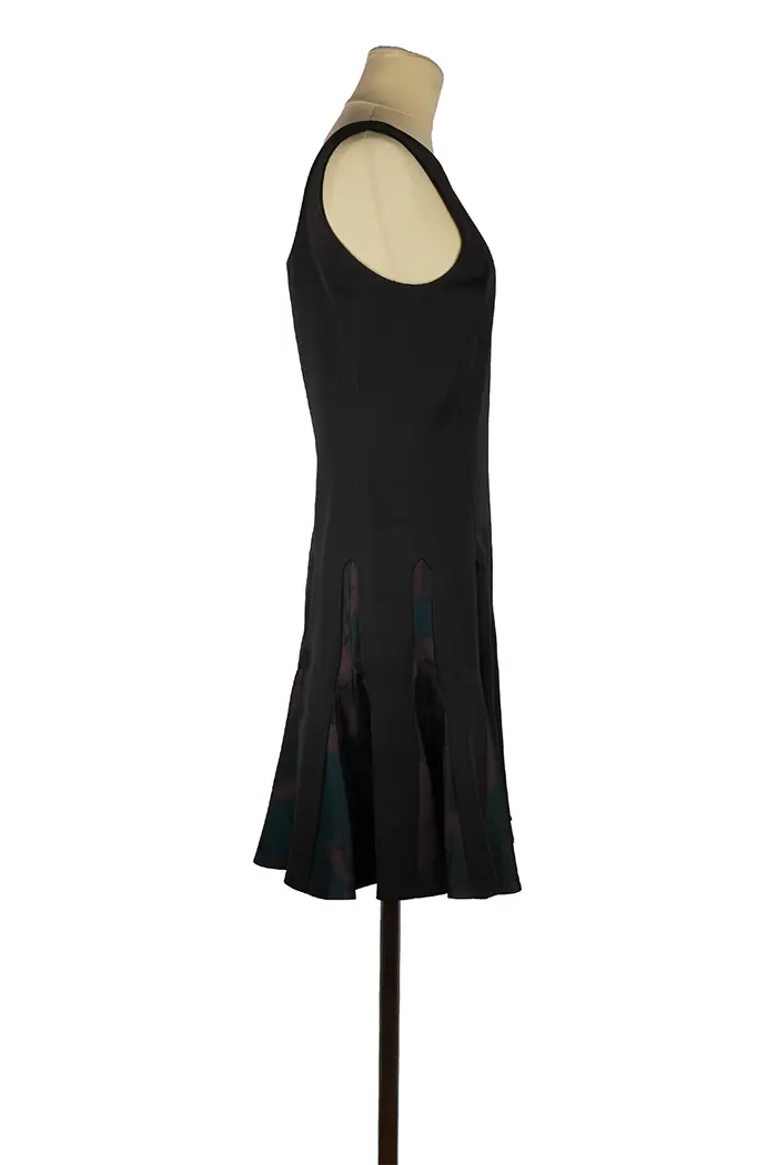 Robe courte Christian Dior en laine et soie satinée sur mannequin, haut noir structuré et jupe imprimée raffinée, idéale pour un look de soirée élégante.