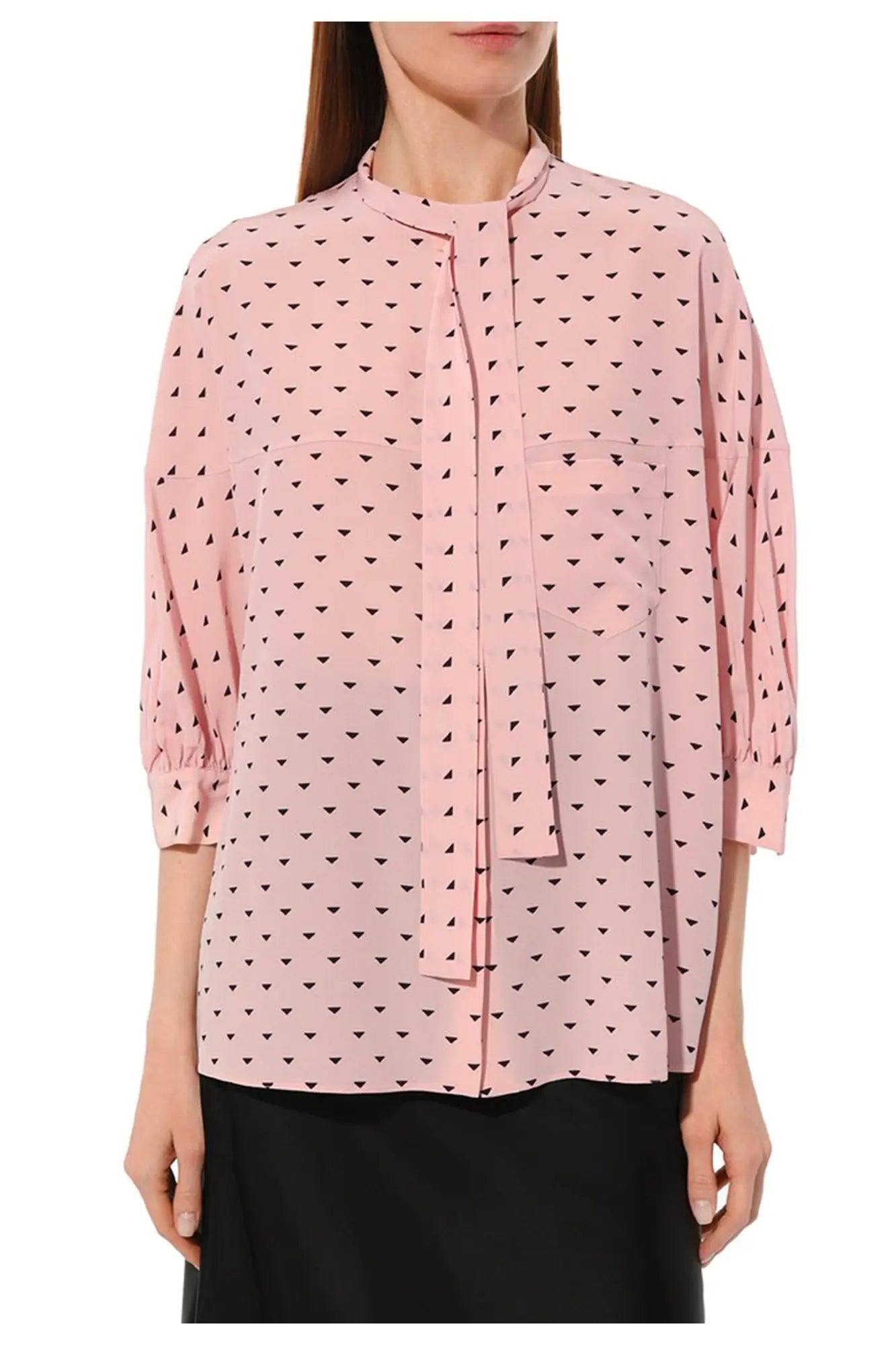 chemisier Prada en soie rose porté loose par un mannequin sur une jupe noire