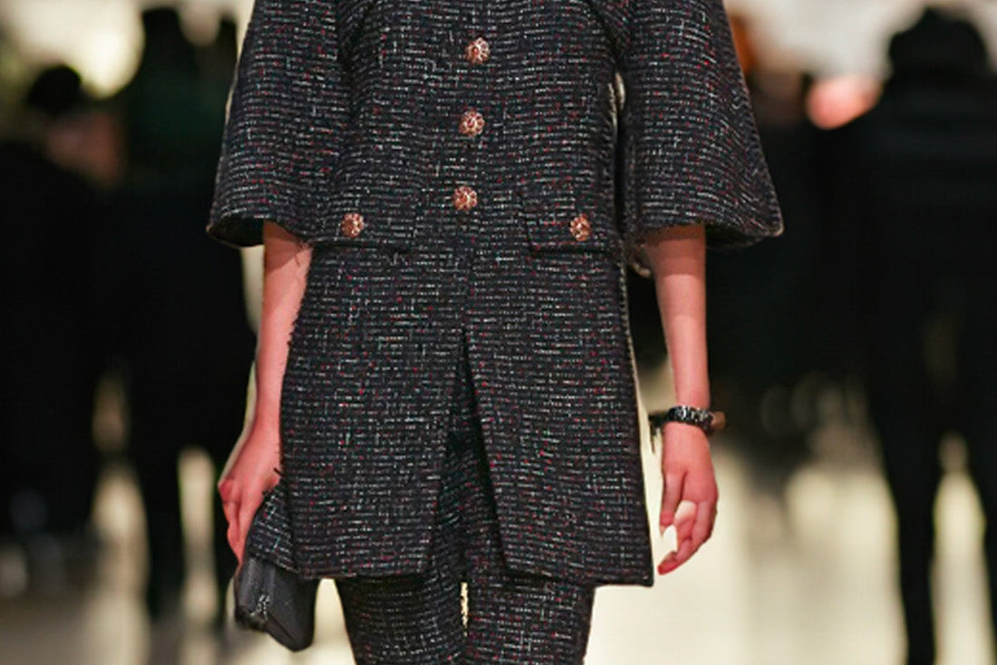 Mannequin portant un manteau noir en tweed lors d’un défilé Chanel – exemple de modèle rare à retrouver chez Reench
