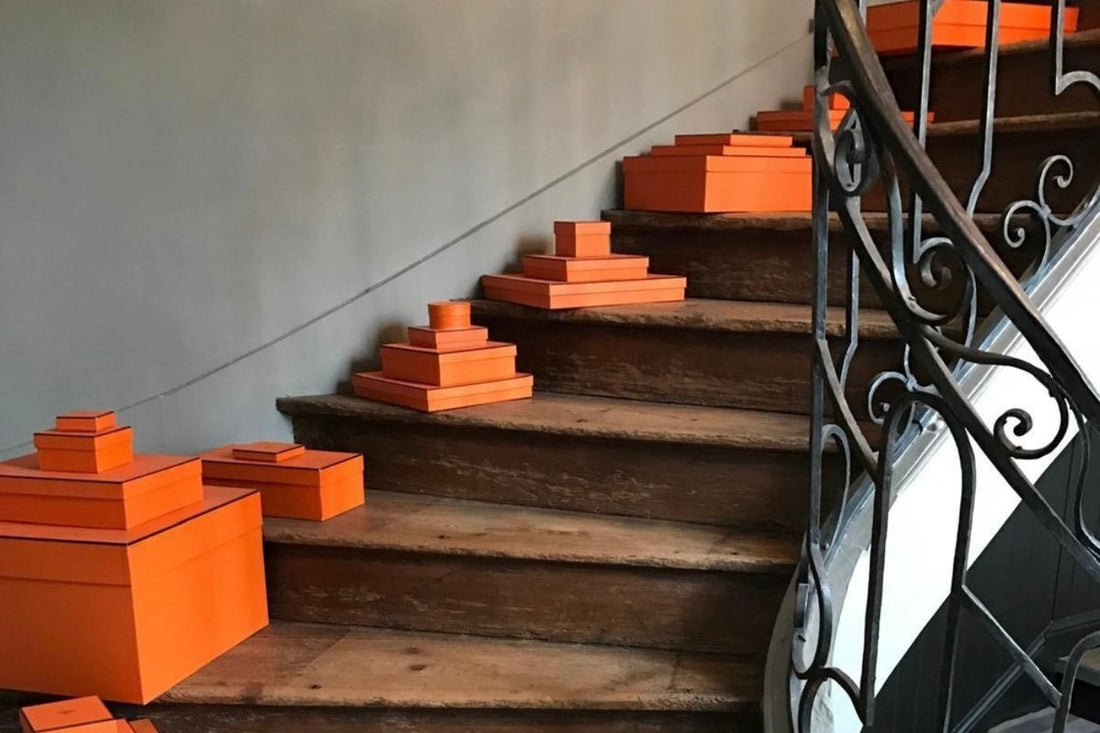 Boîtes Hermès disposées sur les marches d’un escalier dans un hôtel particulier – aperçu du quotidien de nos vendeurs exclusifs Reench