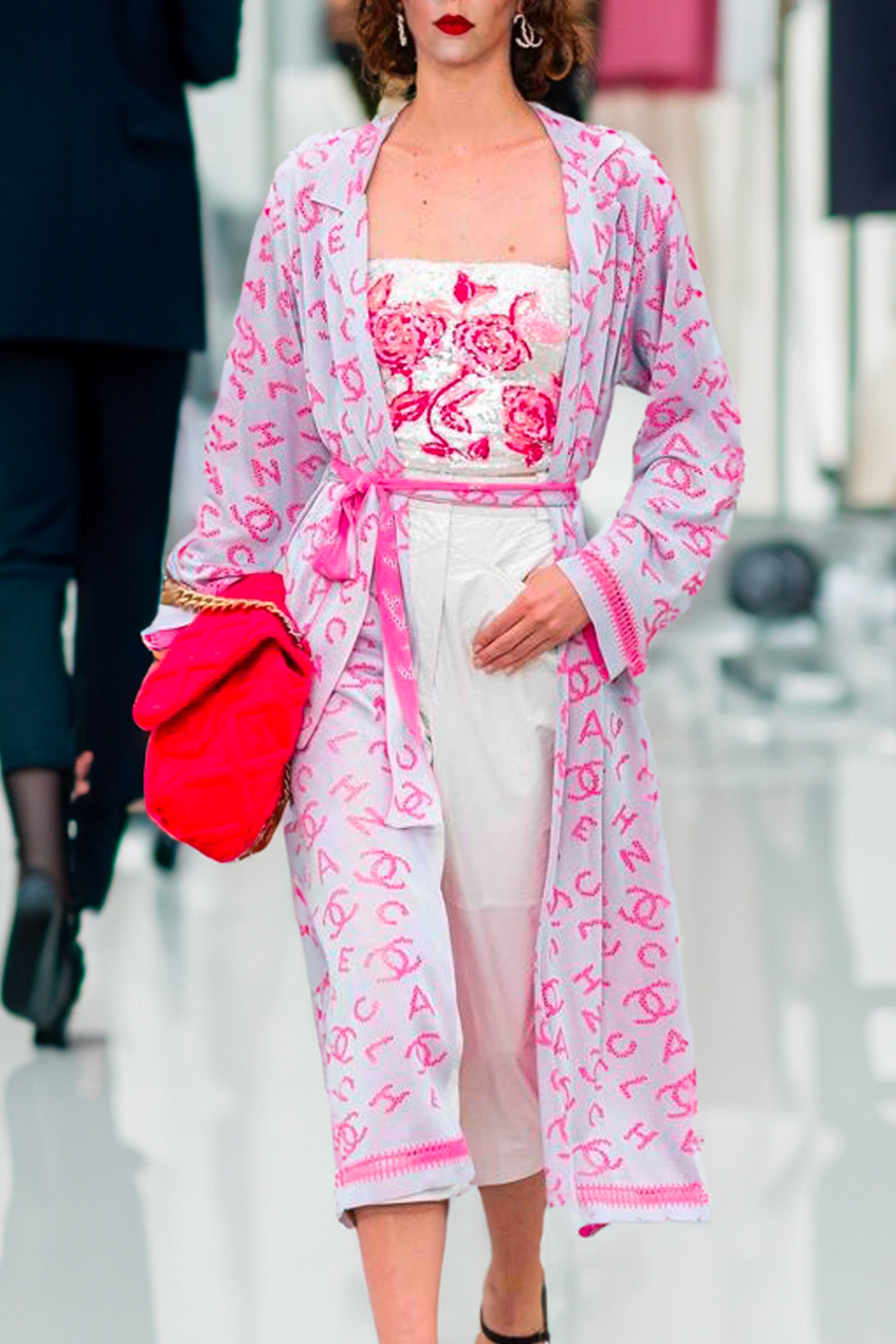 Shot of a model wearing Chanel cardigan with floral top and white pants. Ref. 1000017. Reench.