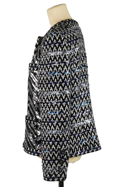 Perfil de la chaqueta gráfica Chanel de tweed y lentejuelas, de silueta estructurada y líneas puras, diseñada por Virginie Viard en talla 40 FR.