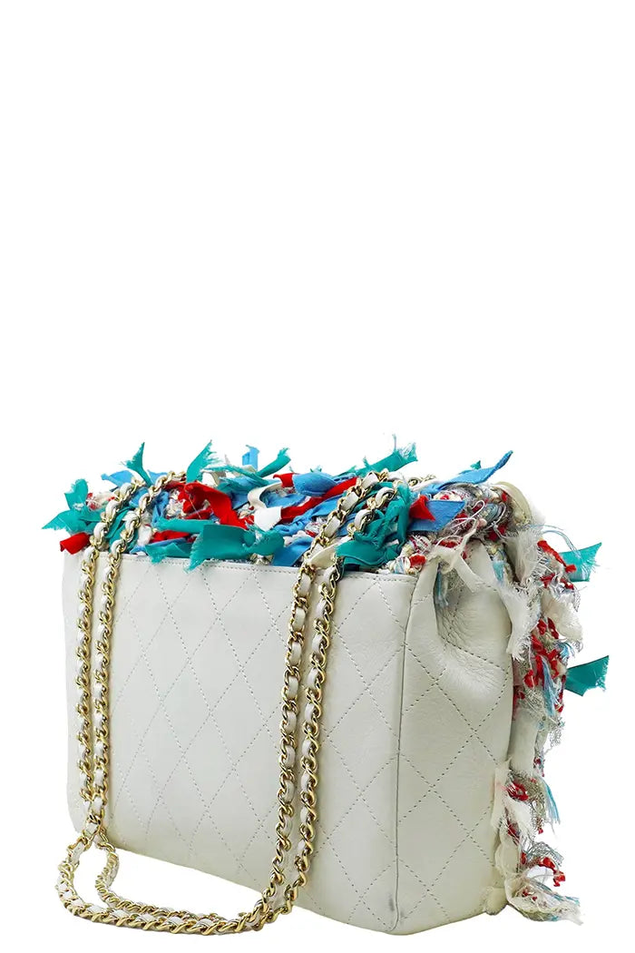 Rückseite der Chanel-Tasche, die das beigefarbene, glatte Kalbsleder zeigt, bildet einen eleganten Kontrast zur bunten, bestickten Vorderseite.