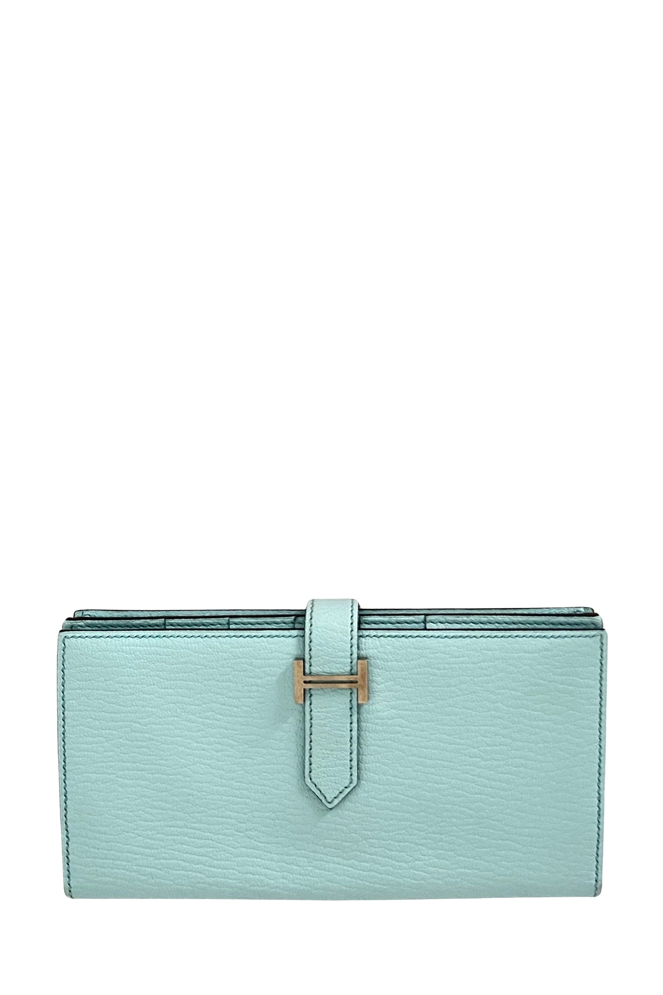 Slim silhouette and strap ending in an elegant H-shaped buckle make the Béarn wallet a Hermès classic. Here, this long model features an elegant Turquoise color, with a gold finish. Ref. 1000054 Hermès second main, Reench.