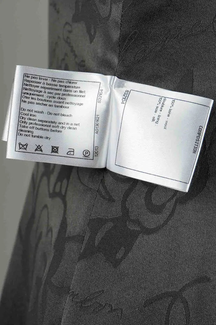 Abrigo de lana gris Chanel , artículo de segunda mano, zoom en la etiqueta de composición