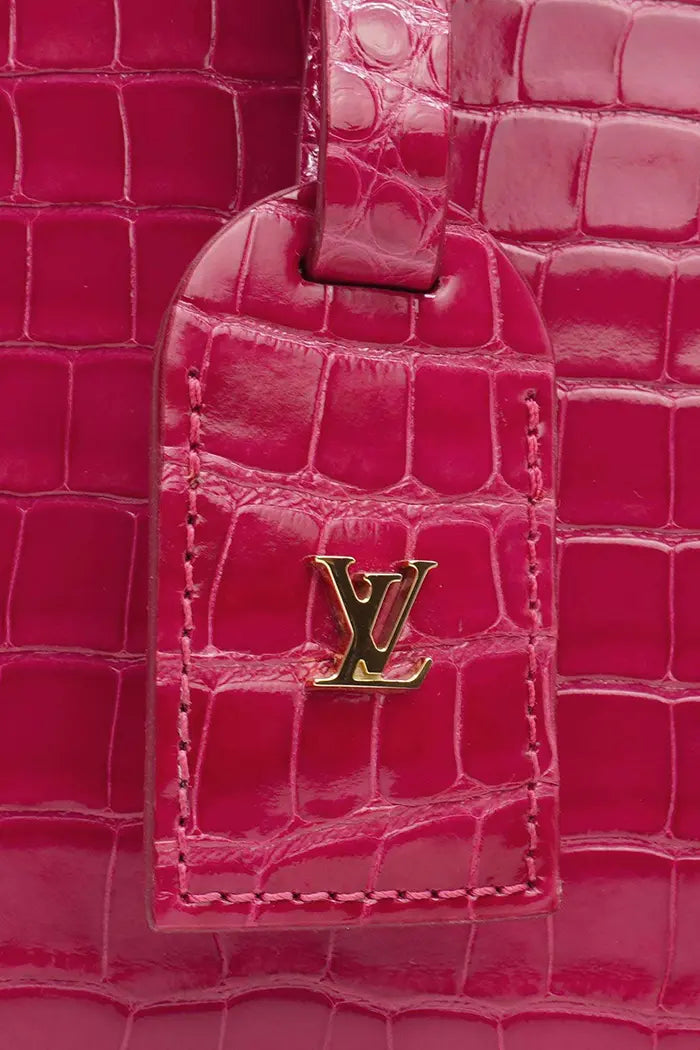 Sac Louis Vuitton 'Petite Boite Chapeau'  rose en cuir d'alligator, article d'occasion, zoom sur l'étiquette de voyage marquée du logo LV