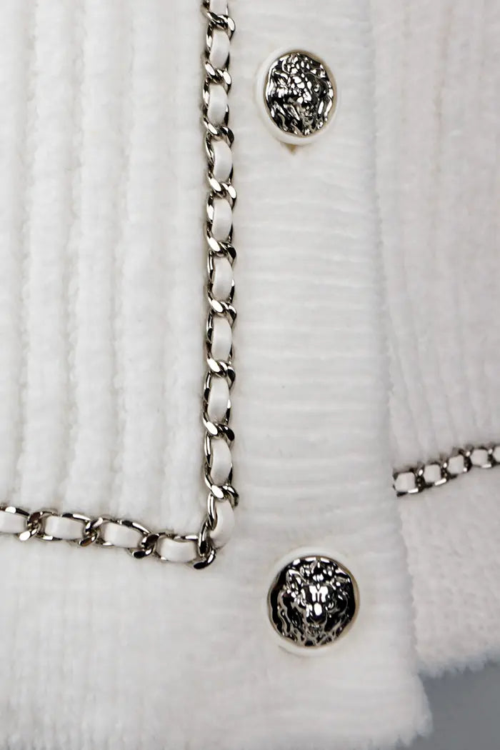 Cardigan Chanel blanc, collection Automne/Hiver 2022, article d'occasion, zoom sur les boutons du bas du cardigan