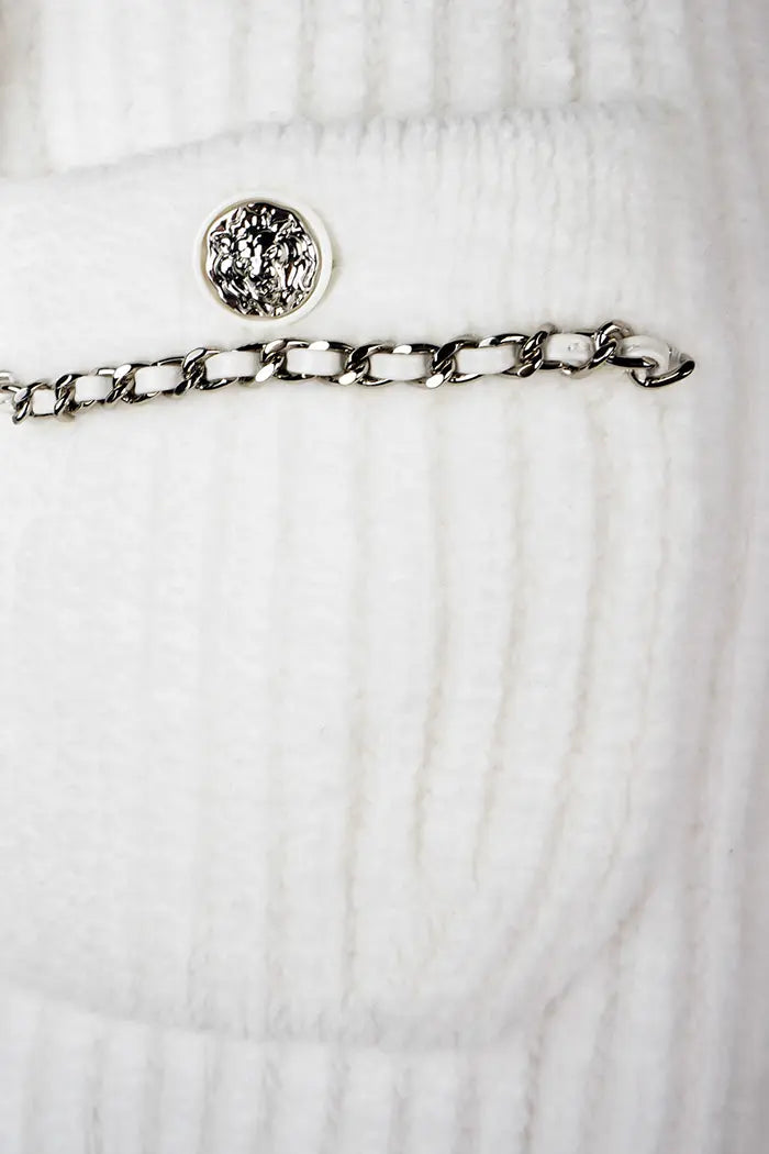 Cardigan Chanel blanc, collection Automne/Hiver 2022, article d'occasion, zoom sur la poche de devant avec son bouton