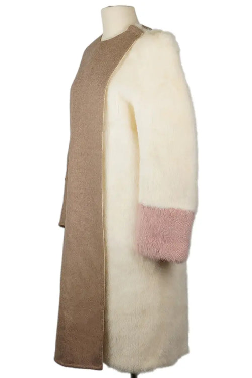 Vista tres cuartos izquierda de abrigo Fendi, manga de piel marfil con acabado rosa empolvado.