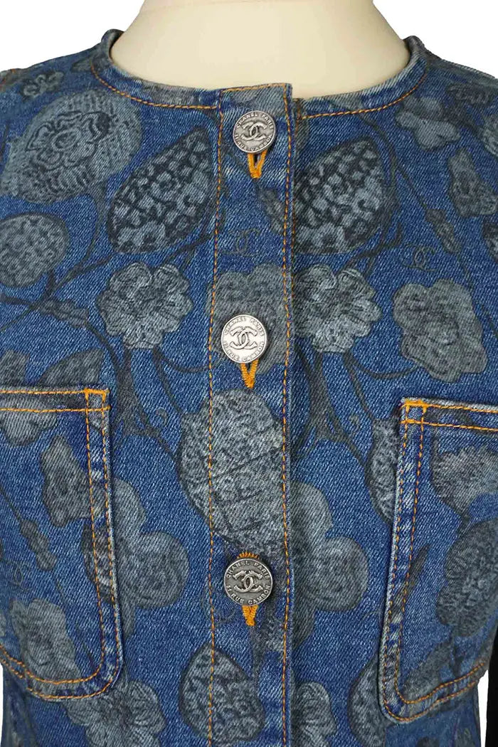 Chanel Chaqueta vaquera azul de manga larga con motivos florales, artículo seminuevo, zoom en los botones CC de la parte delantera