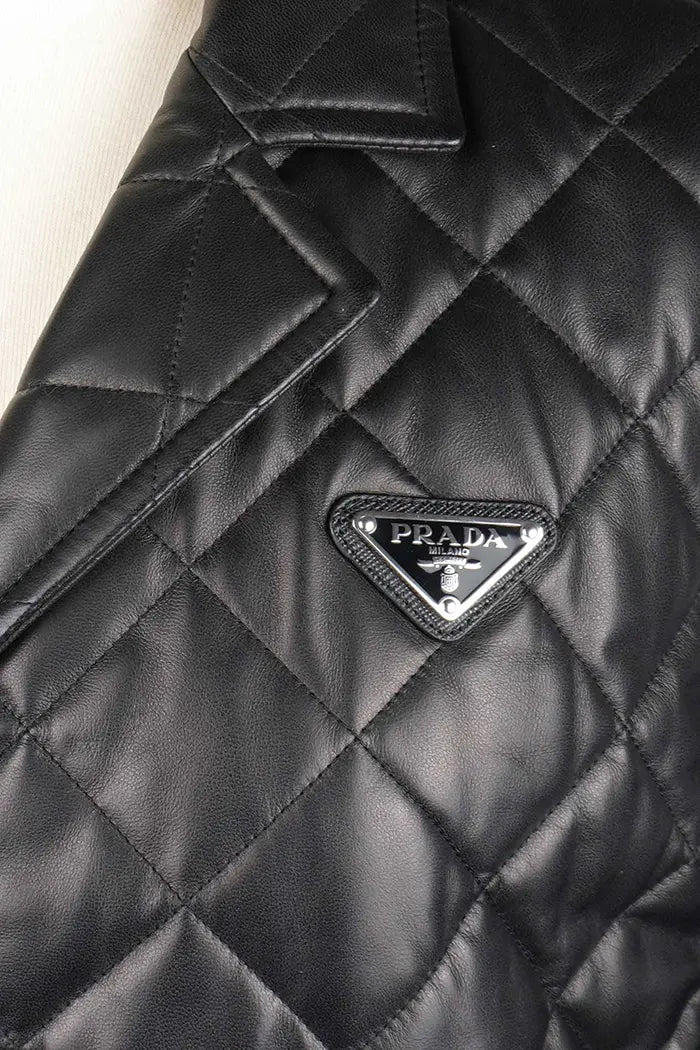 Chaqueta Prada acolchada negra en piel de cordero napa, artículo seminuevo, foco en el icónico logotipo de Prada