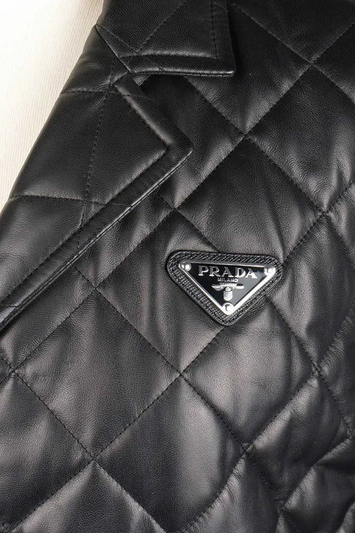 Chaqueta negra acolchada de Prada en piel de cordero napa, artículo seminuevo, foco en el icónico logotipo de Prada
