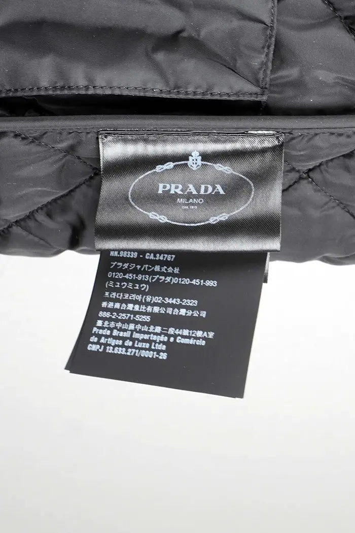 Chaqueta Prada acolchada negra en piel de cordero napa, artículo de segunda mano, zoom en la etiqueta Prada