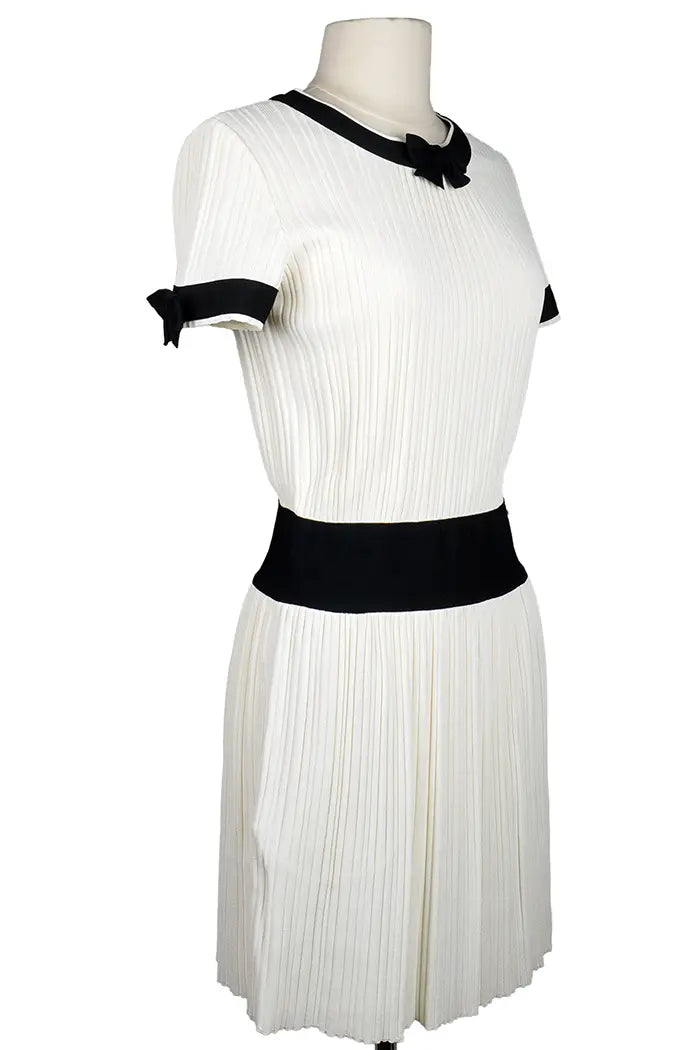 Vestido Chanel en color crema con detalles y lazos negros, artículo seminuevo, 3/4 vista