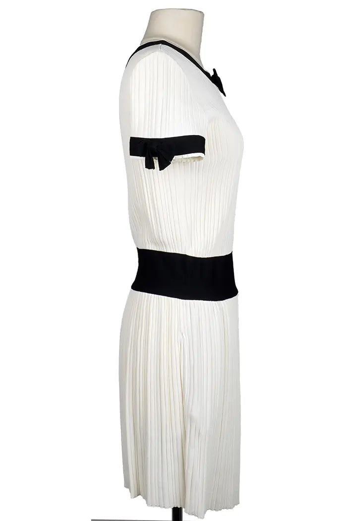 Vestido Chanel en color crema con detalles y lazos negros, artículo seminuevo, vista lateral