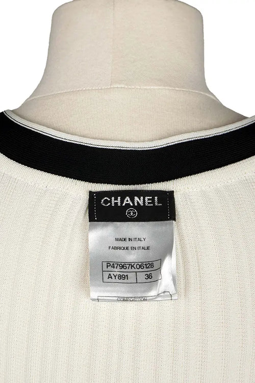 Chanel mini-vestido crema con detalles negros y lazos, artículo seminuevo, zoom en la etiqueta