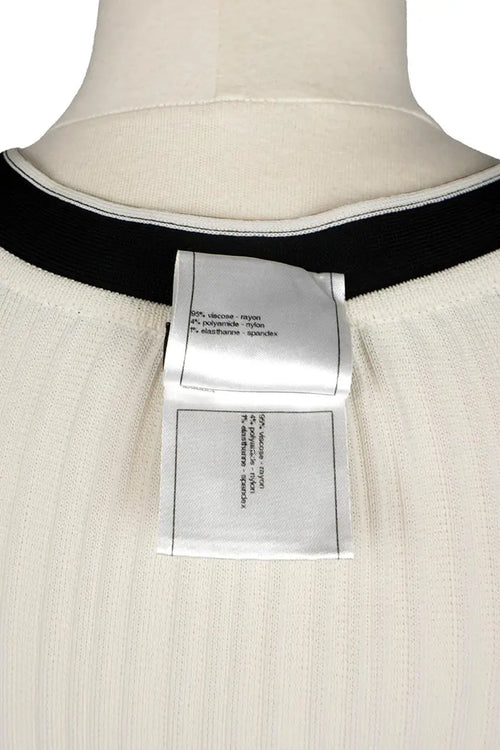 Chanel mini-vestido crema con detalles negros y lazos, artículo seminuevo, zoom en la etiqueta de composición