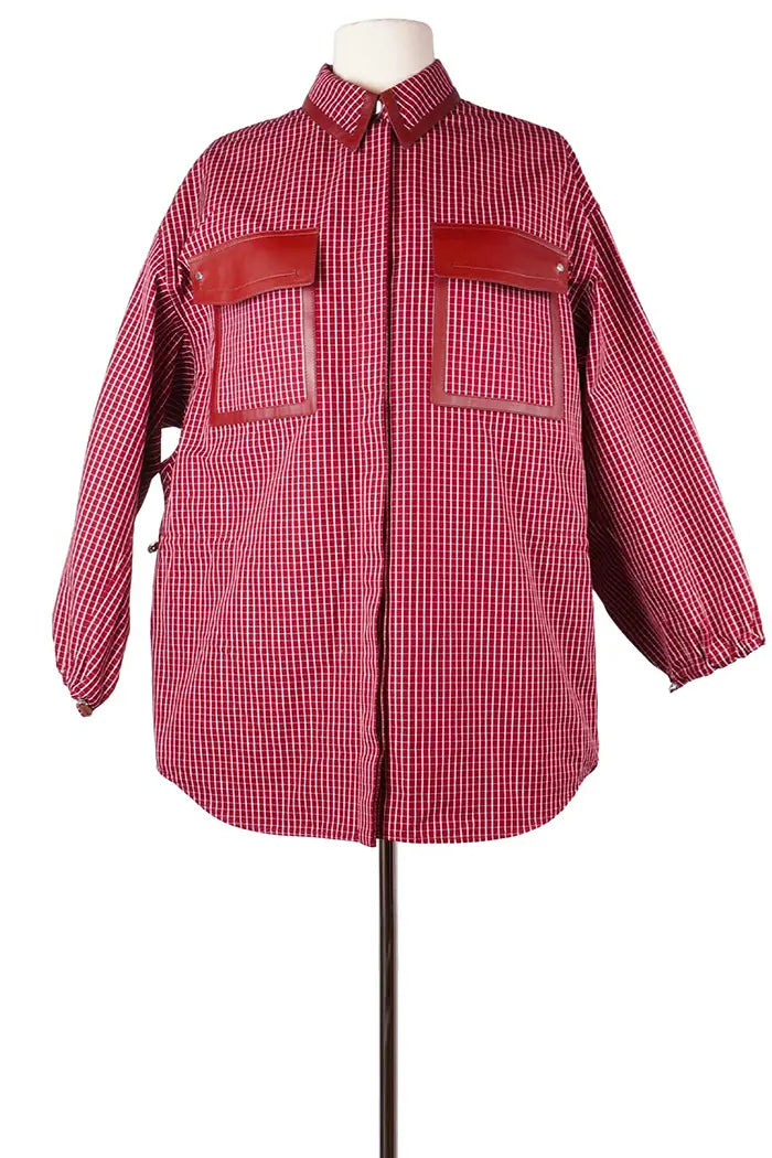 Vue de face, côté droite d'une sur-chemise Hermès en coton, article d'occasion, à carreaux rouges, taille ample