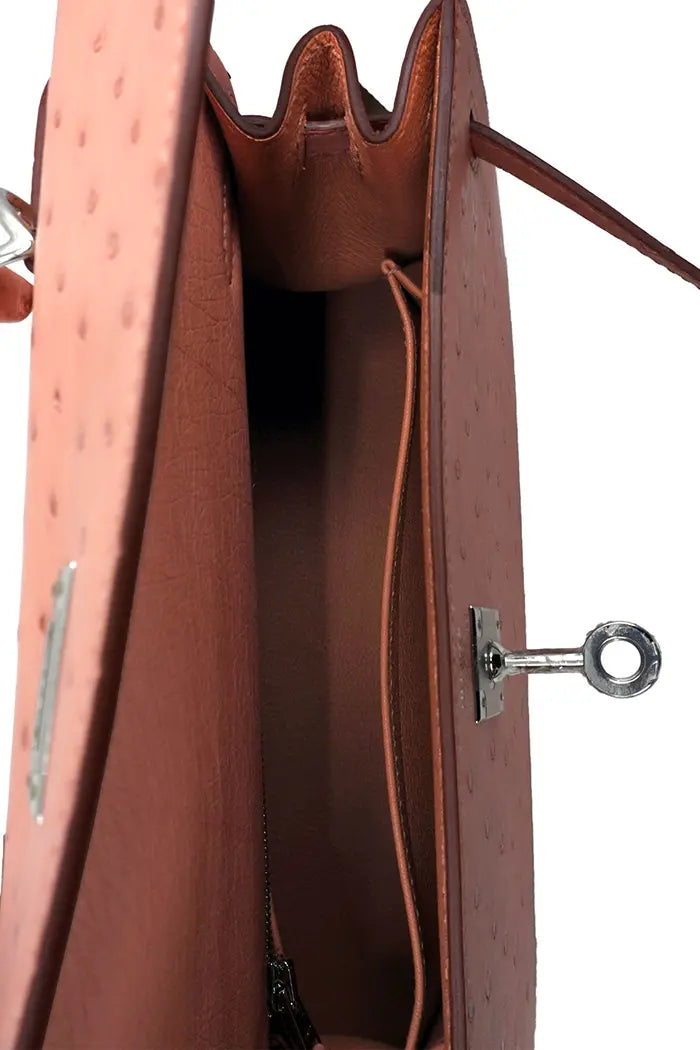 Blick auf die geöffnete Tasche des Kelly 25 in Terrakotta-Straußenleder.