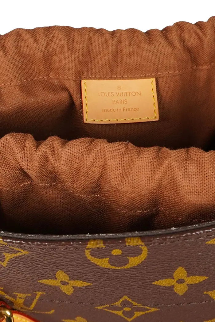 Vista superior del bolso usado Louis Vuitton  Louis Vuitton With Holes, con el bolsillo abierto con el logotipo de Louis Vuitton.