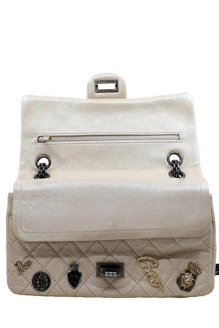 Vista frontal del bolso Chanel 2.55 preloved, primera solapa levantada, mostrando una segunda solapa