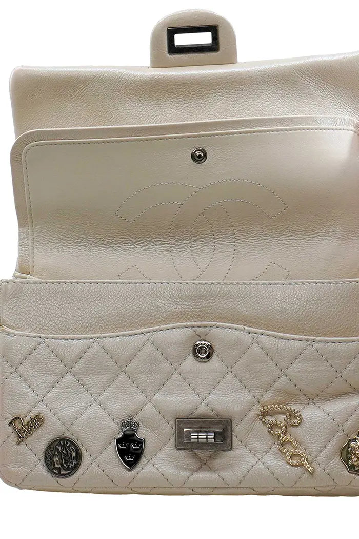 Vista frontal del bolso Chanel 2.55 preamueblado, con las 2 solapas levantadas, revelando 2 bolsillos secundarios