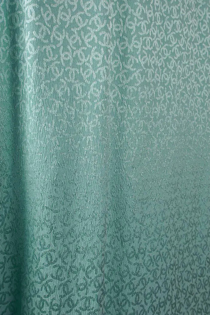 Zoom sur la soie turquoise à imprimé CC de la tunique Chanel preloved