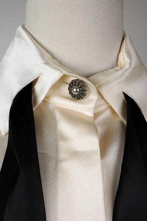 Detalle del botón en el cuello y de los botones ocultos en la parte delantera de la camisa Chanel de seda preciada