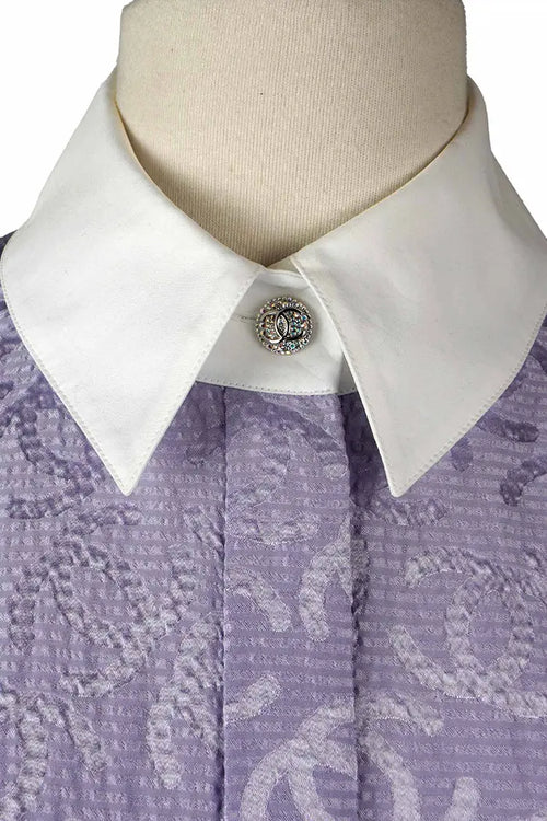 Gros plan sur les boutons brillants à motif CC entrelacés de la tunique Chanel preloved