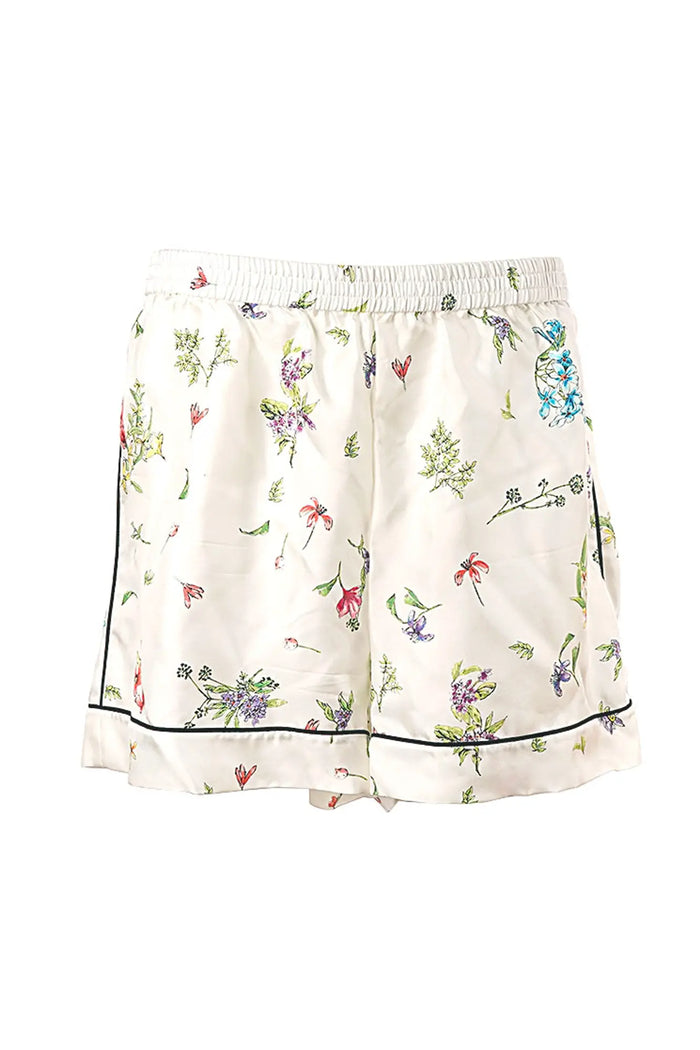 Nahaufnahme der passenden Shorts zum Dior-Ensemble aus weißer Seide mit Sternbilddruck und zarten Abschlüssen - perfekt für einen hochwertigen Loungewear-Look.