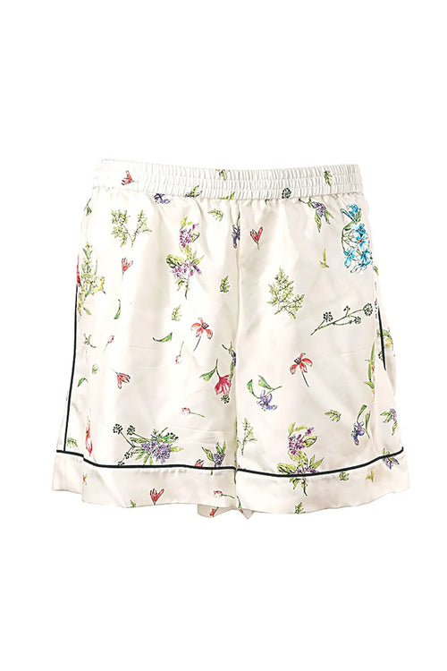 Detalle del short a juego con el conjunto Dior de seda blanca, estampado de constelaciones y delicados acabados, perfecto para un look loungewear de alta gama.