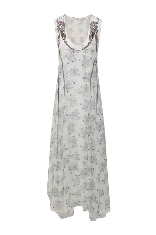 Chloé-Kleid aus weißer Seide an einer Schaufensterpuppe, naiver Blumendruck, kontrastierende Stickerei am Ausschnitt, fließende Passform und asymmetrische Länge.