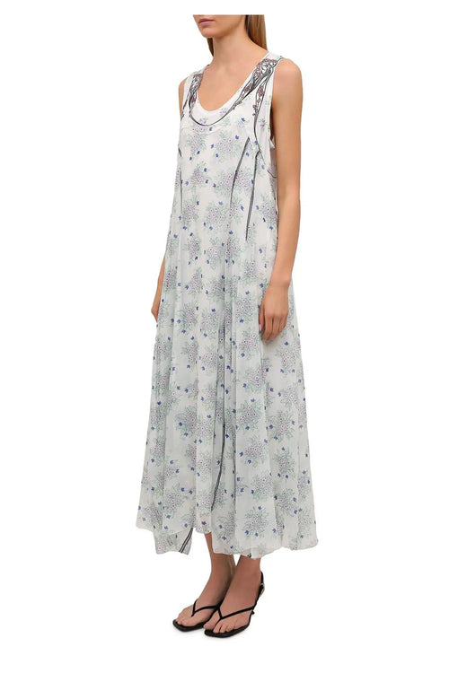 Chloé-Kleid für Frühjahr/Sommer 2021, das in einer Situation getragen wird. Der fließende, asymmetrische Schnitt aus leichter Seide unterstreicht eine feminine und elegante Silhouette.