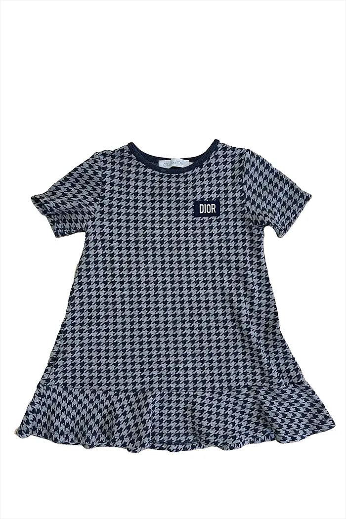 Baby Dior Kleid für Mädchen, von vorne gesehen, Hahnentrittmuster in Marineblau und Grau mit gesticktem DIOR Logo auf der Brust.