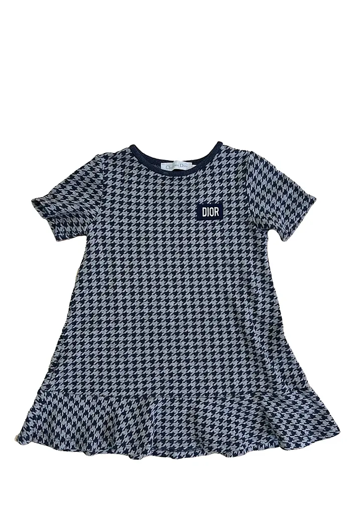 Robe Baby Dior pour fille, vue de face, motif pied-de-poule bleu marine et gris avec logo DIOR brodé sur la poitrine.