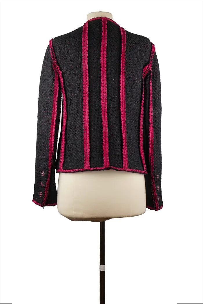 Rückseite der Chanel Jacke aus marineblauem Tweed, gerader Schnitt und kontrastierende Ärmel, sorgfältige Verarbeitung, die typisch für das Haus ist.