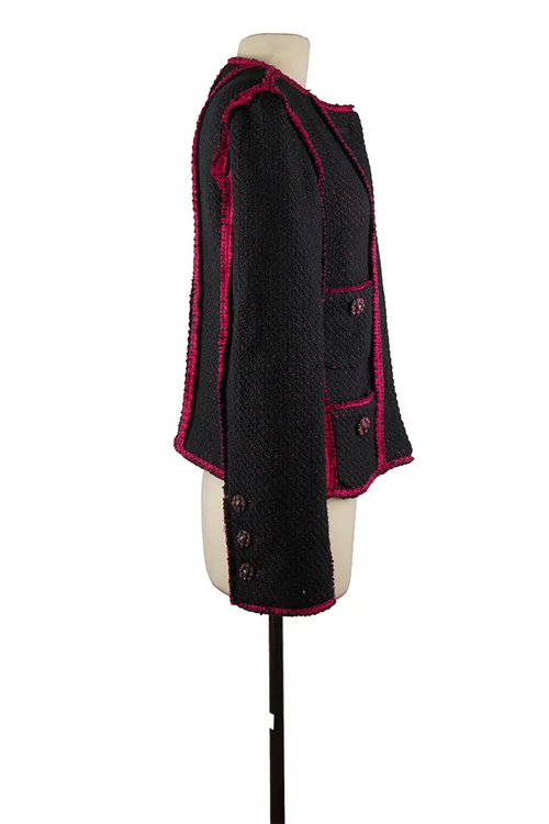 Vista lateral derecha de la chaqueta de segunda mano de Chanel, con una combinación gráfica de azul marino y fucsia, un corte estructurado y detalles de alta costura.