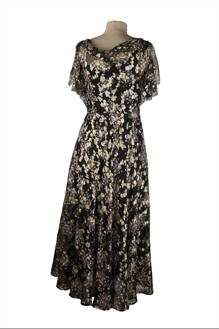 Dos de la robe Valentino sans manches, taille cintrée et ligne épurée, finitions soignées sur un tissu noir aux reflets dorés discrets.
