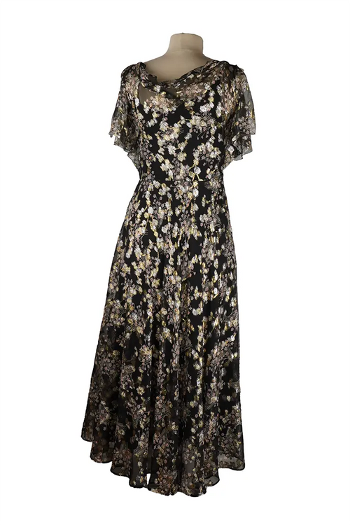 Dos de la robe Valentino sans manches, taille cintrée et ligne épurée, finitions soignées sur un tissu noir aux reflets dorés discrets.