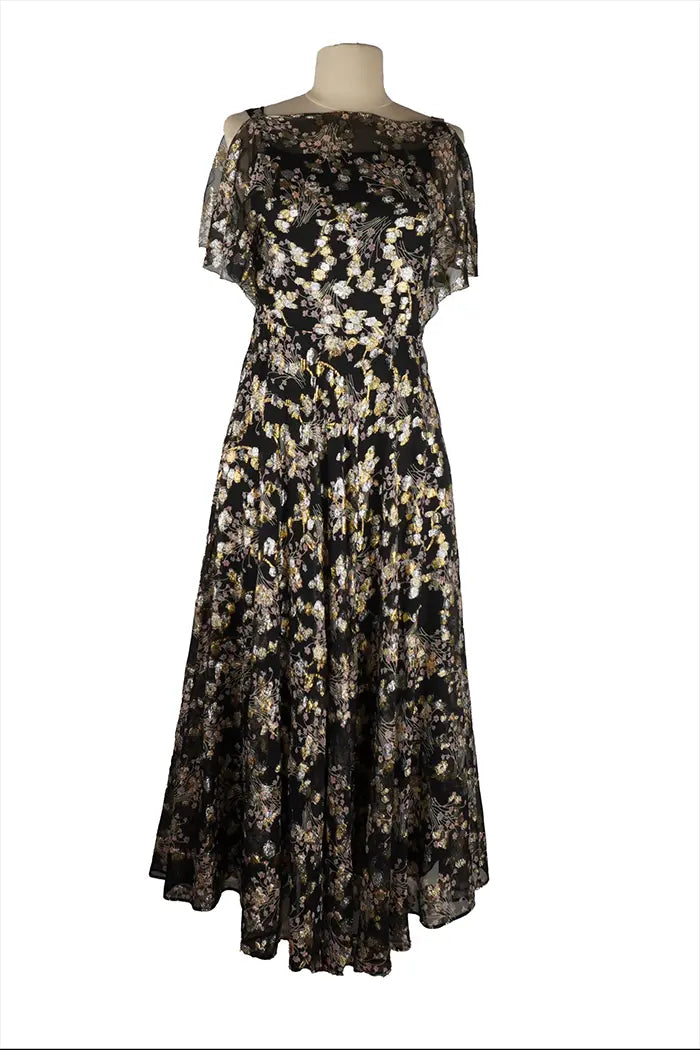 Robe midi noire Valentino sans manches sur mannequin, tissu structuré avec fibres dorées, coupe ajustée à la taille et décolleté discret pour un look cocktail élégant.